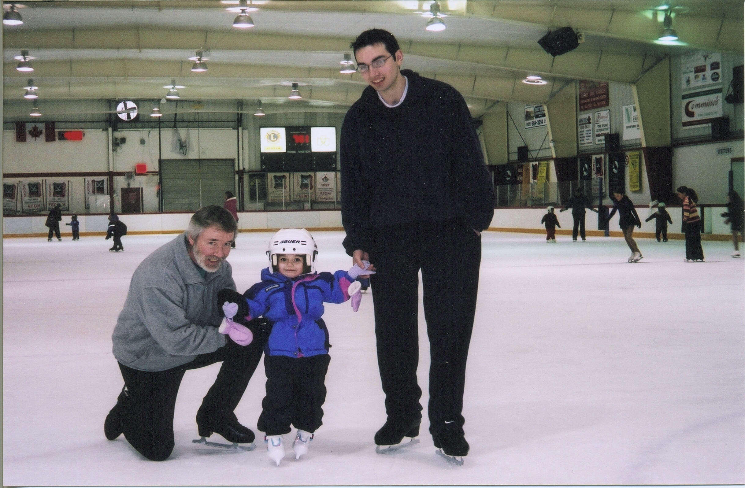 family of skaters on the ice smiling